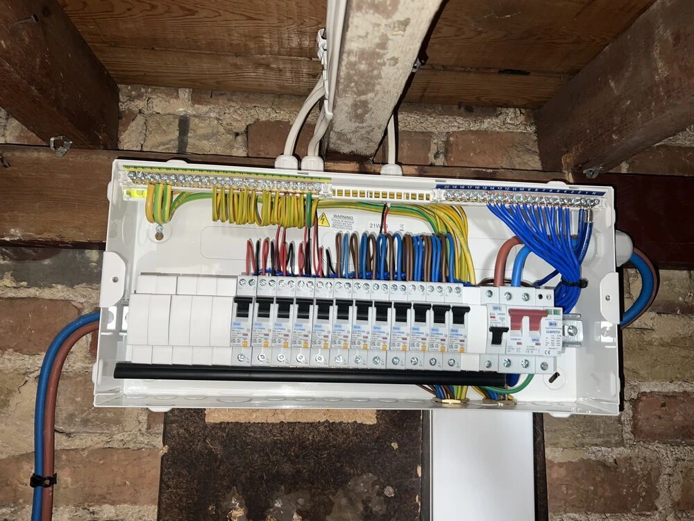 New consumer unit with neatly labelled circuits fitted on exposed brickwork