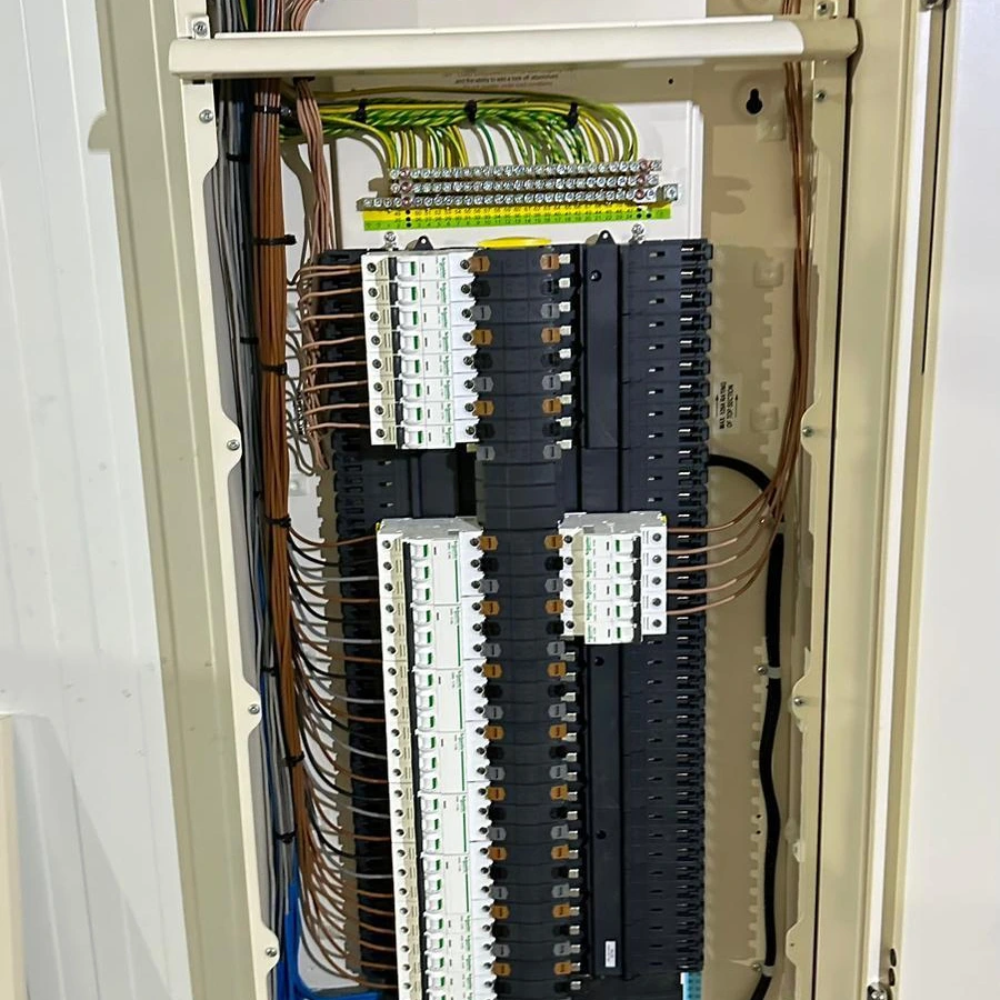 Tall floor-standing distribution board with rows of circuit breakers and labelled cables