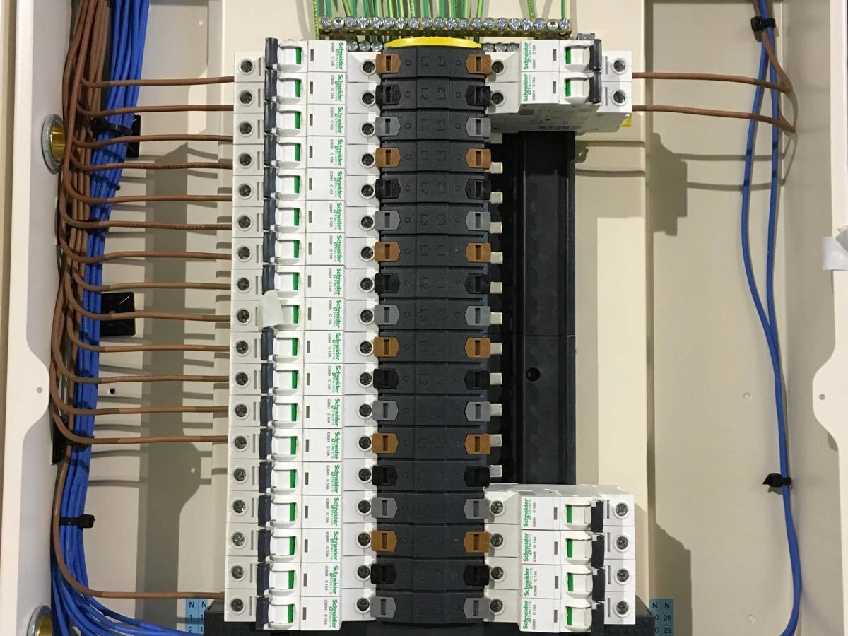 Large distribution board with tidy blue and brown wiring and rows of circuit breakers